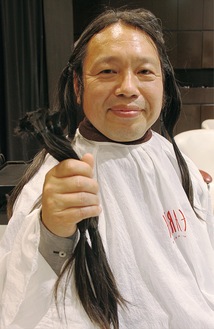 切った髪を持って笑顔の松本さん