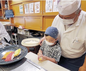 梶さんの指導で寿司を握る児童＝提供