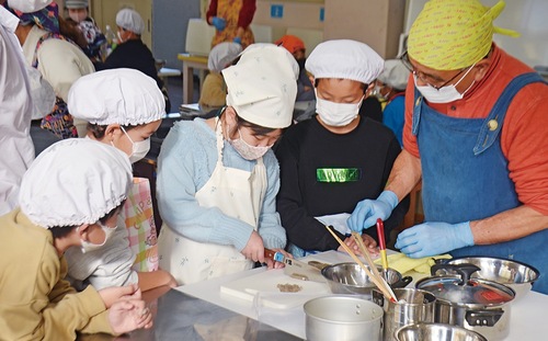 県人会の指導を受け調理する児童たち