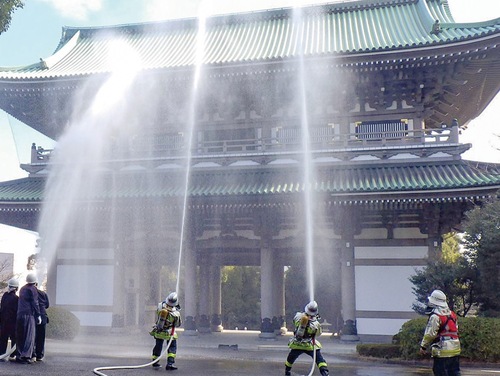 三門に放水する署員と自衛消防隊