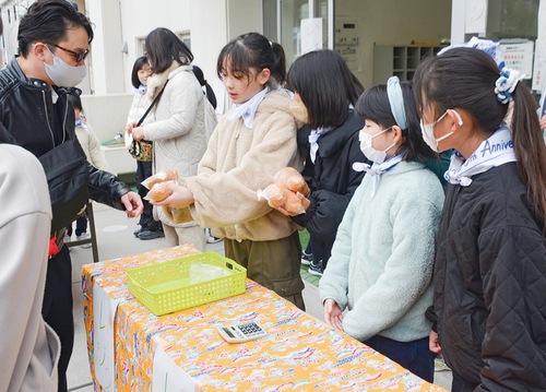 笑顔で販売する児童たち