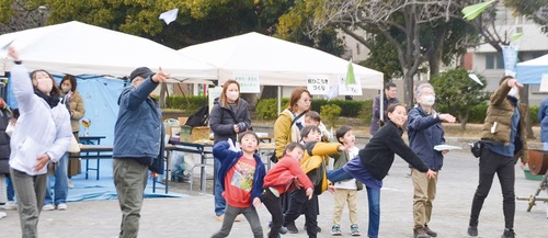 紙飛行機を飛ばす参加者たち