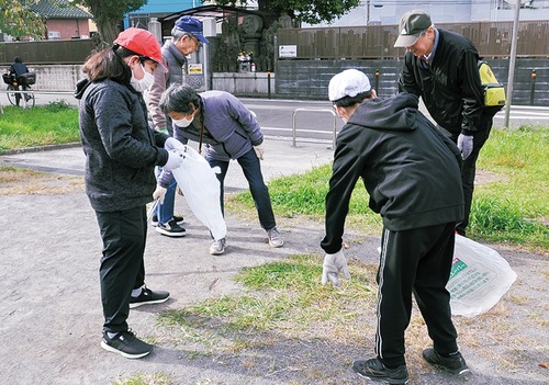大人と一緒にごみを拾う児童たち