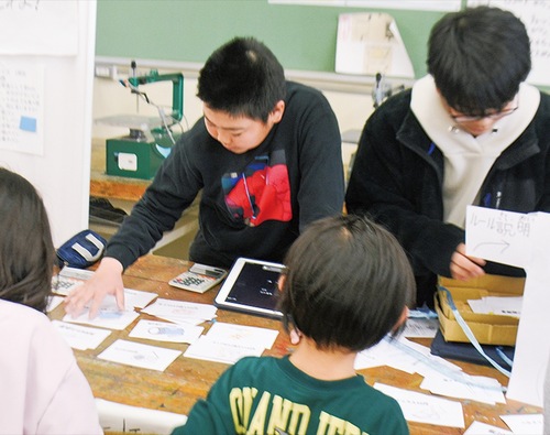 防災ショップゲームで楽しむ児童たち
