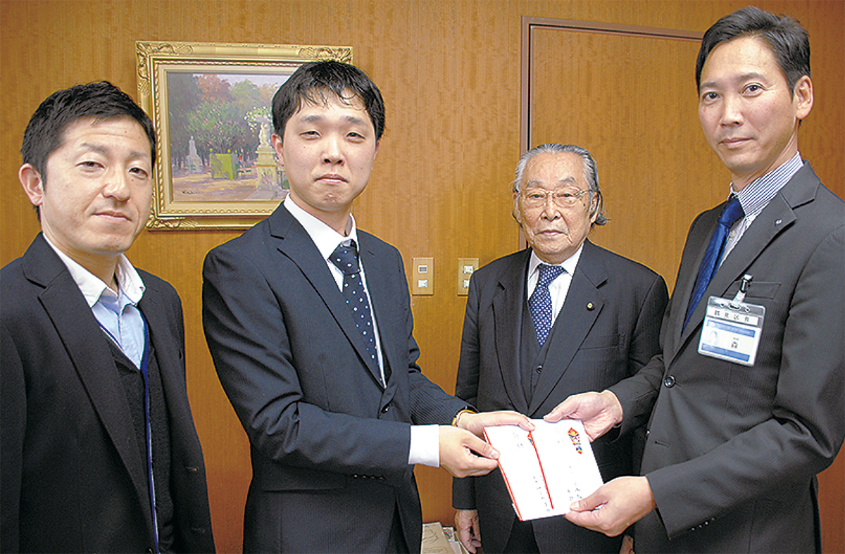 森健二区長に手渡す植竹事務局長と本部事務局次長の山本哲さん(左)