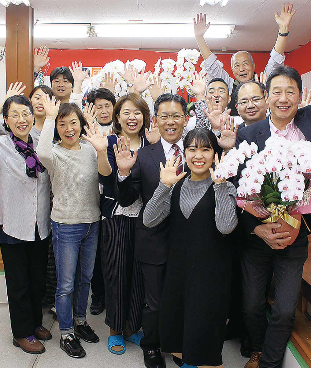 支援者らと喜ぶ尾崎氏(中央)