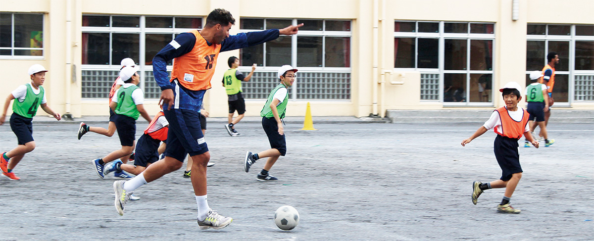 サッカーを通じて交流する児童と選手