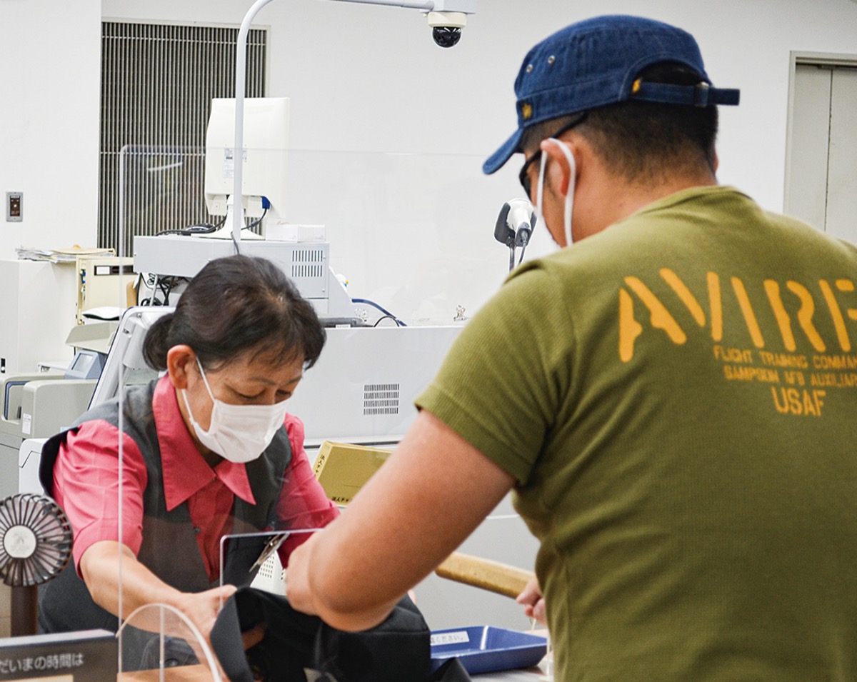 迫真の演技で犯人役が行員を脅迫