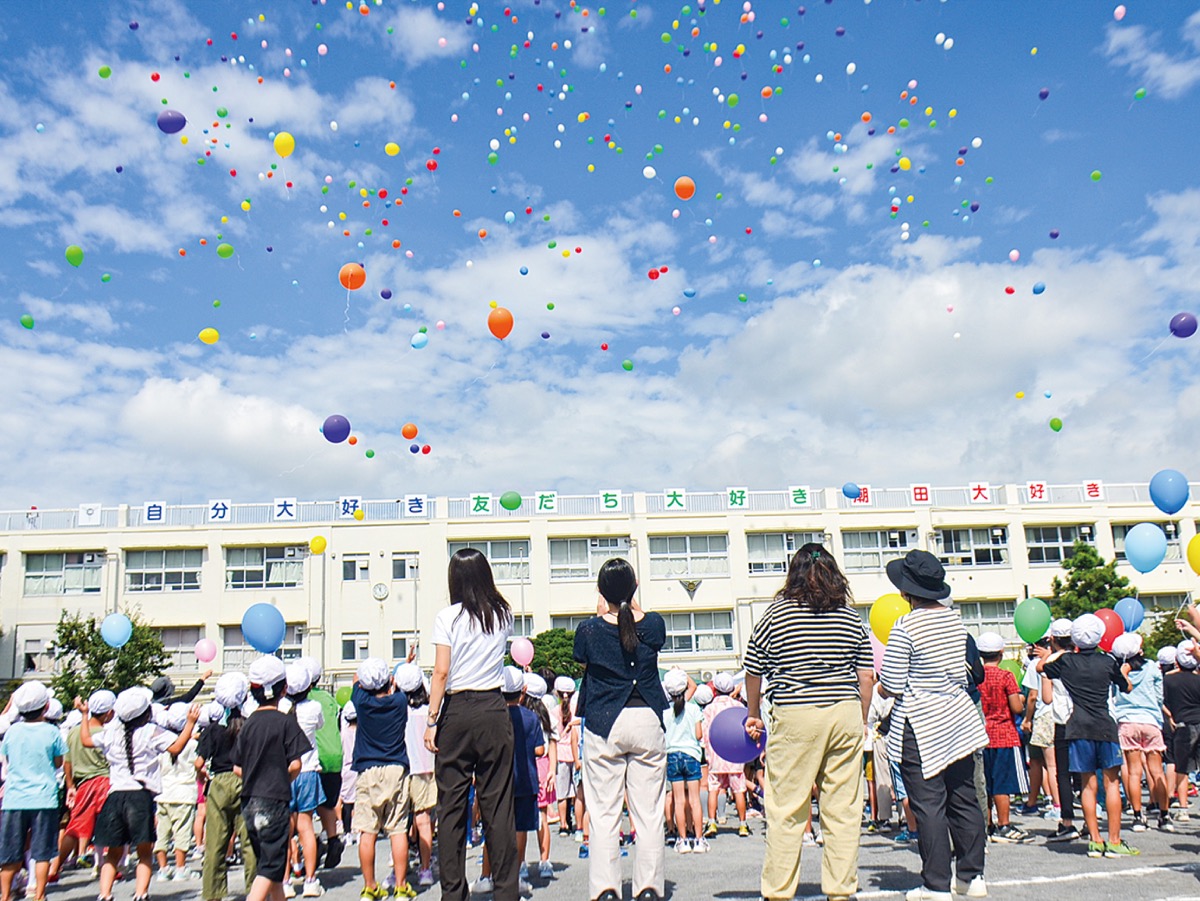 空へ放った風船を見送る児童たち