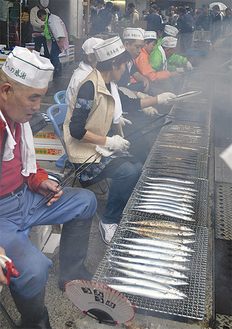 炭火でサンマを焼く魚屋の人たち