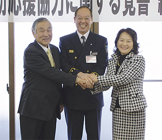 調印を終え笑顔の幡野会長（左）、小川専務理事（右）と松原署長