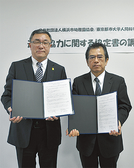 協定書を手にする木元会長（左）と近藤学部長