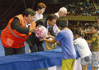 子どもたちから花束を受け取る伊坂理事長（左）ら