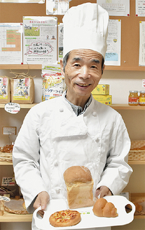 笑顔で自慢のパンを紹介する村上さん