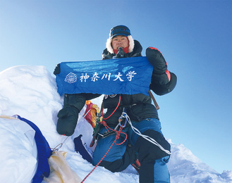 山頂で記念撮影をする畠山さん（写真は本人提供）