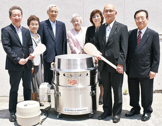 寄贈した法人会メンバーと高田靖区長（左）