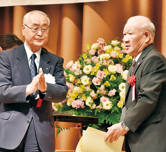 受賞者を称える市交通安全協会の板橋悟会長（左）
