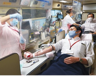 感染症対策を取った献血バス内で献血を行う様子
