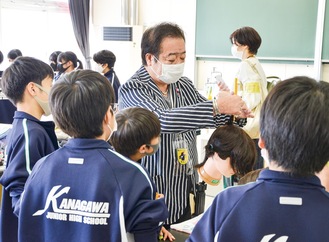 宇佐美さん（中央）にロッドの巻き方を学ぶ生徒
