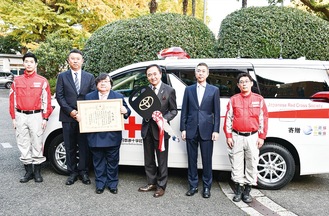 車両を寄贈する伊坂会長（左から３人目）