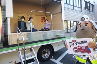 起震車を体験する人たちと横浜市消防局マスコットキャラクター「 ハマくん」