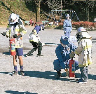 水消火器の扱いを学ぶ子どもたち