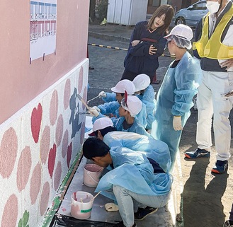 外壁を塗る青木小の児童たち