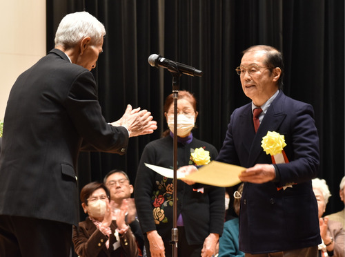 区社協の河原史郎会長（左）から感謝状を受け取る受賞者