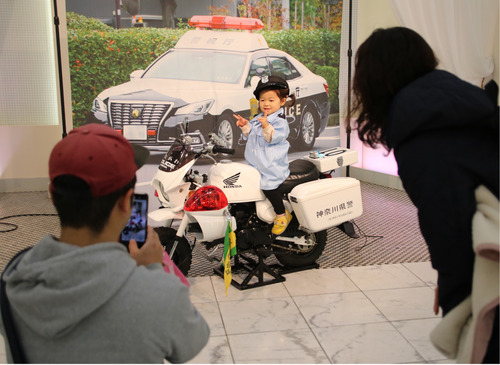 警察官になりきって記念撮影を行う親子