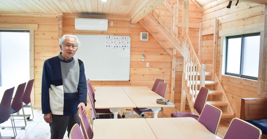 ログハウス風の室内を案内する糸岡会長