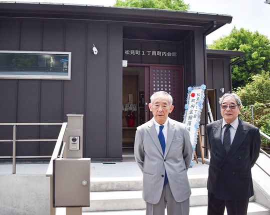 新会館の前に立つ、岡谷前会長（左）と瀧本現会長