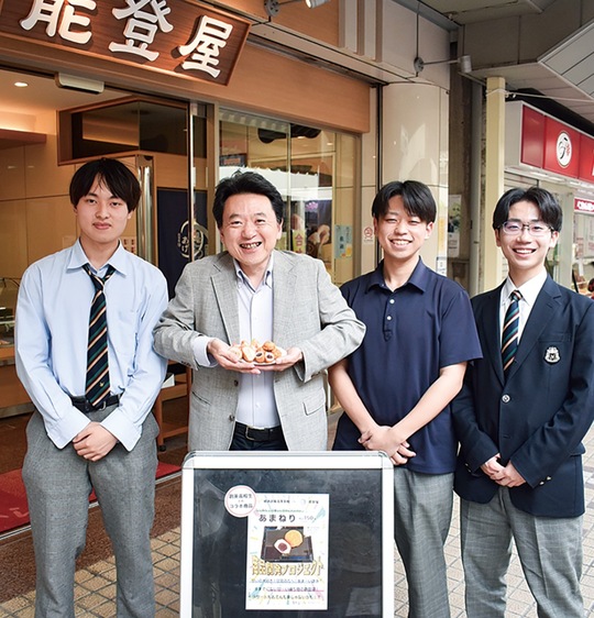 開発に関わった横浜創英高校の生徒と、商品を持つ能登屋の北出社長