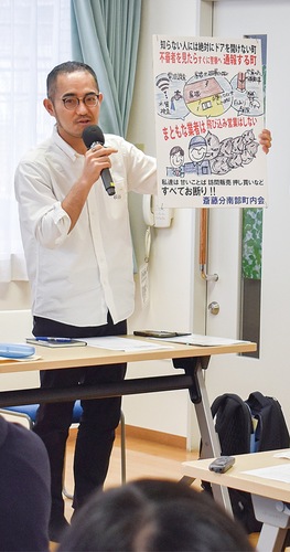 訪問販売撃退のポスターを紹介する、斎藤分南部町内会の萩谷会長