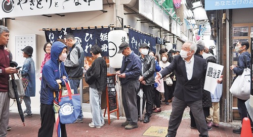 店の脇に列を作る人々