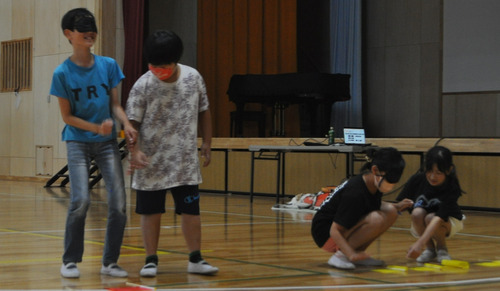 目隠しをしてビーチフラッグに挑戦する児童たち