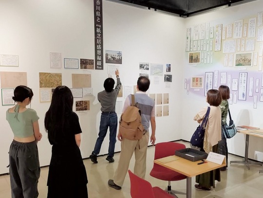 展示の説明をする学生（左奥）＝新垣准教授提供