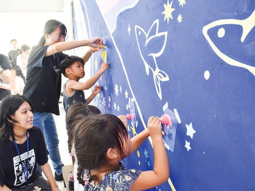 型に合わせて色を塗る子どもたち