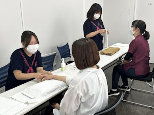 患者や職員にハンドマッサージを施す学生たち