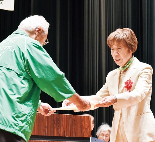 奥田会長（左）から表彰を受ける永年功労者