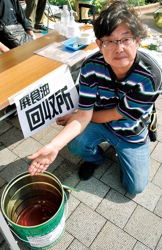 回収した廃食油を見せる斉藤代表