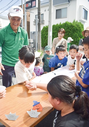 腕相撲の様子を後ろで見守る前田会長