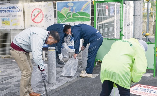 駅前階段下のごみ拾いをする参加者