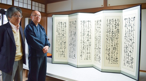 屏風に仕立てた自筆の長歌三首と樋口住職（右）、増田さん