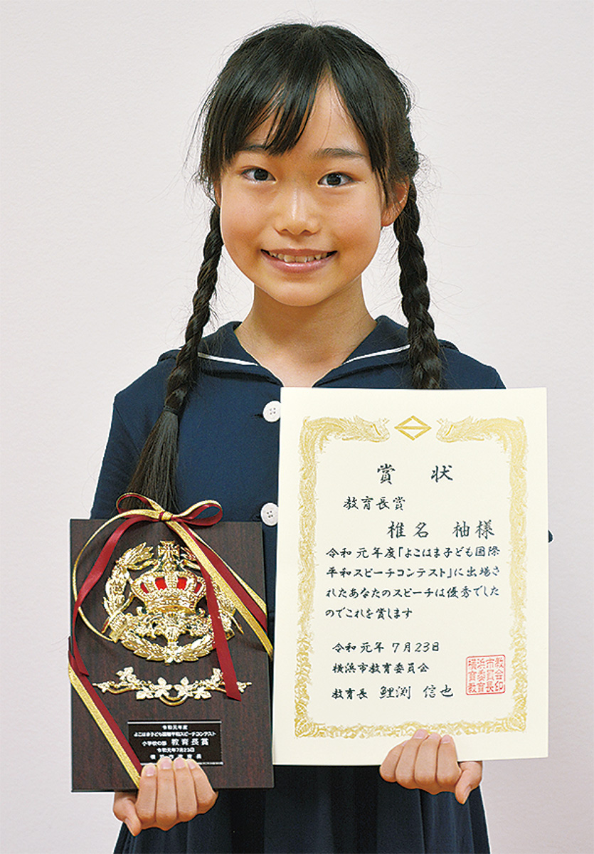 賞状と盾を手にする椎名さん