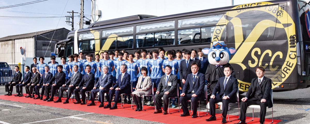 納車されたラッピングバスと式典に出席した関係者ら