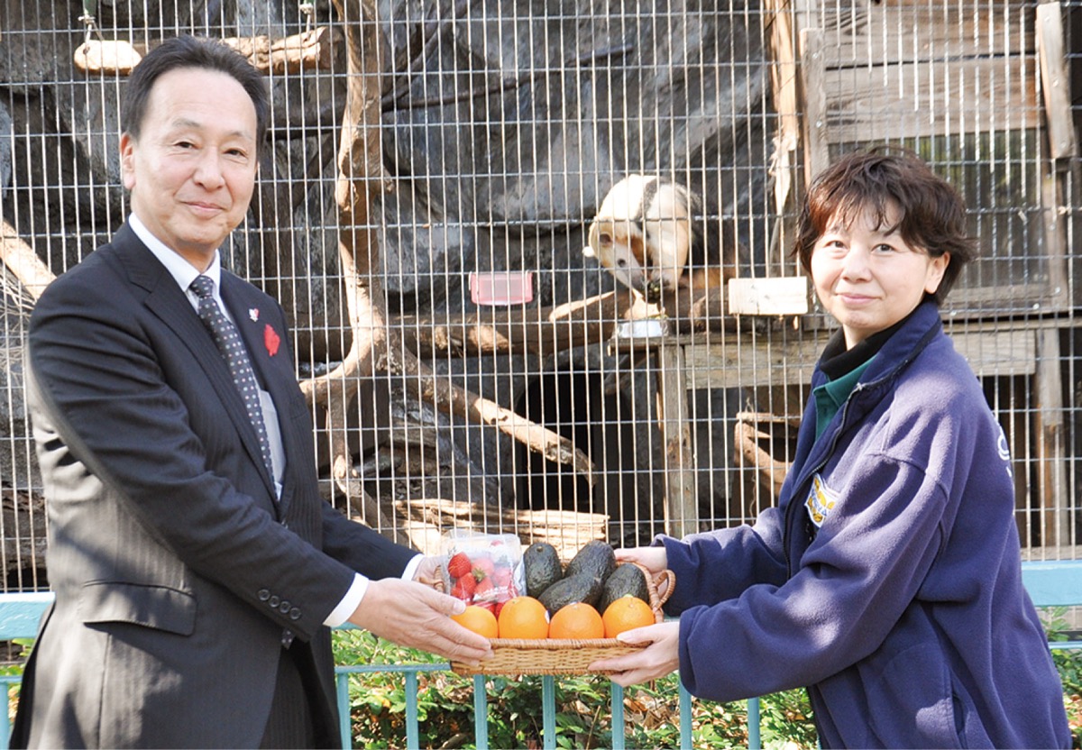 プレゼントの果物を手渡す中島常務理事（左）と田村園長
