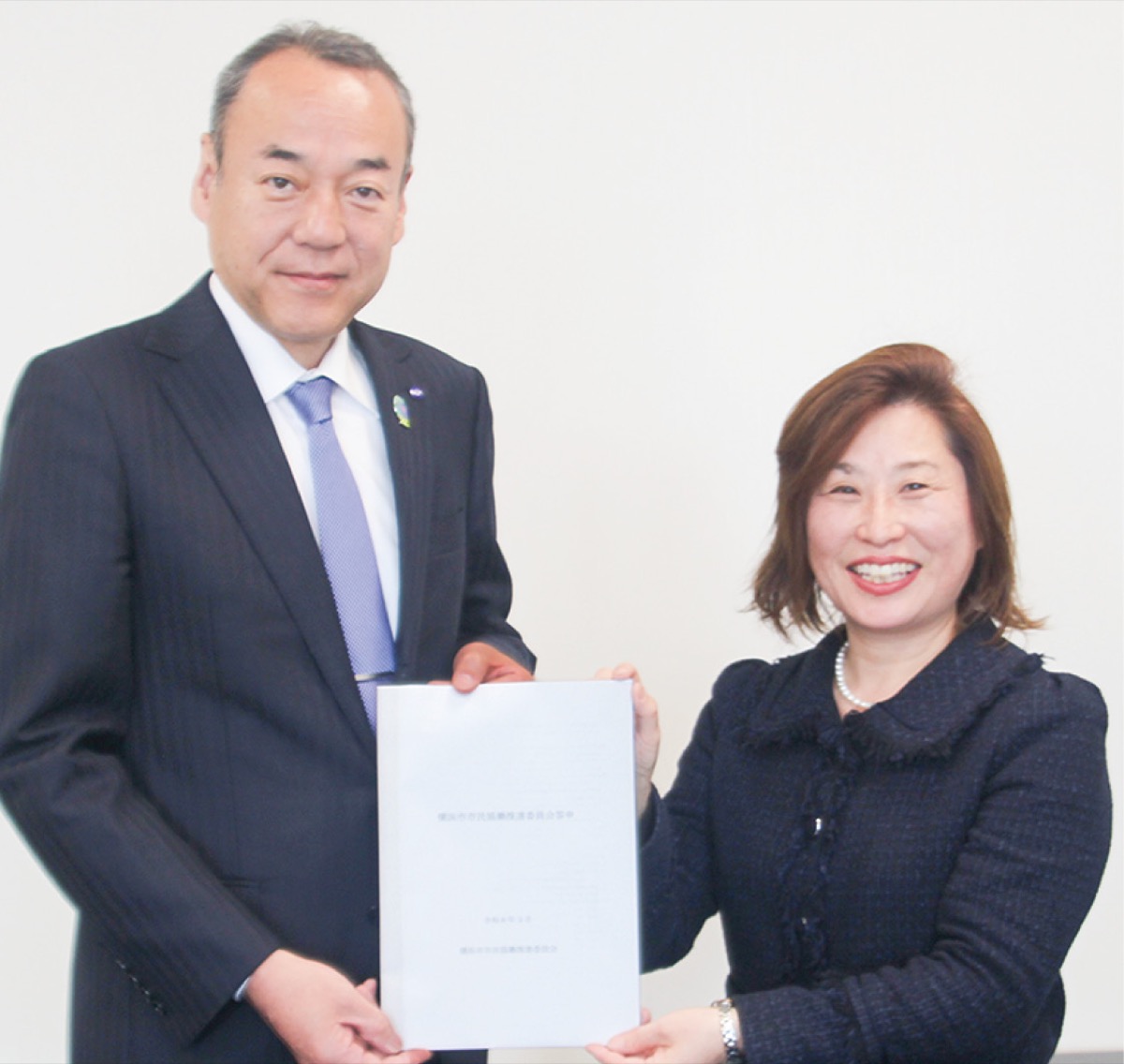 佐藤副市長（左）に答申を手渡す齊藤委員長