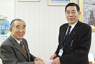 和田区長（右）に義援金を届ける川島会長（左）
