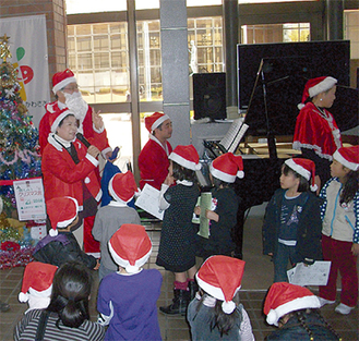 サンタ帽をかぶり一緒に歌う子どもたち