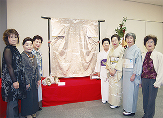鈴木会長（右から４人目）所蔵のスワトウ刺繍訪問着を囲む会員ら